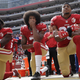 Colin Kaepernick, center, takes a knee during the national anthem, sparking a national debate about athletes and social activism.